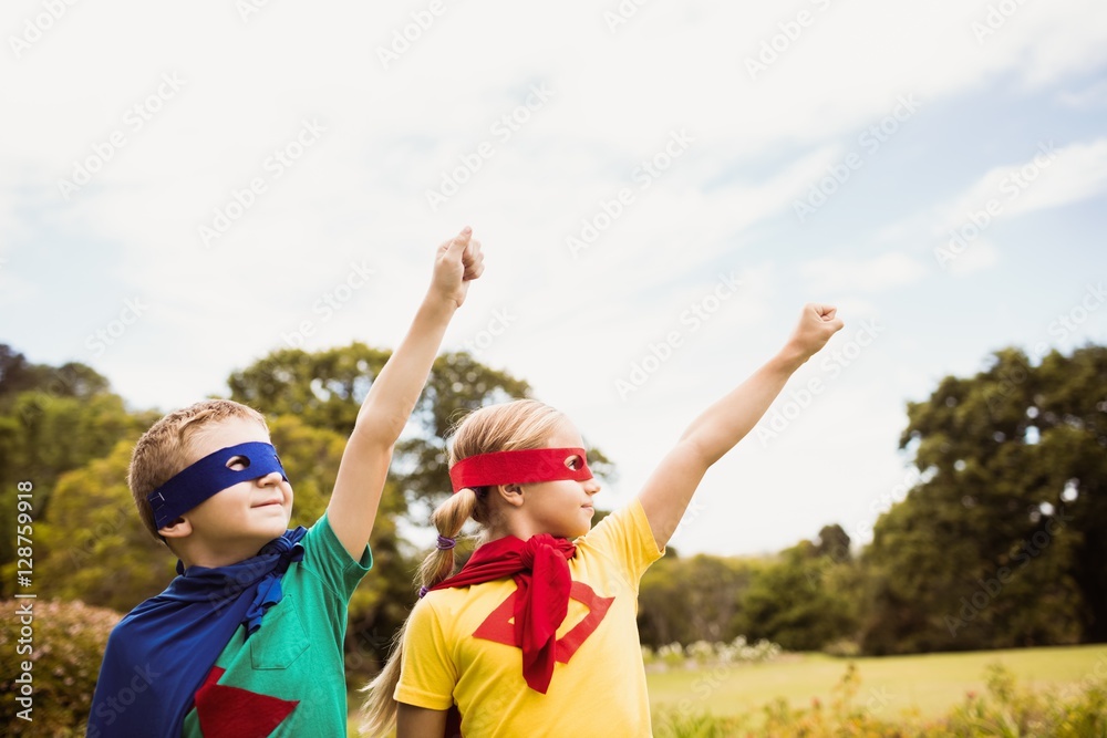Two cute children pretending to fly in superhero costume Two cute children pretending to fly in superhero costume