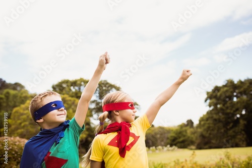 Two cute children pretending to fly in superhero costume