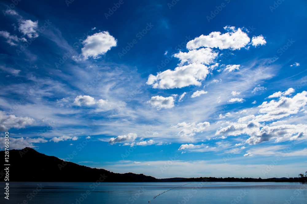 Lake or river and mountain with clouded blue sky