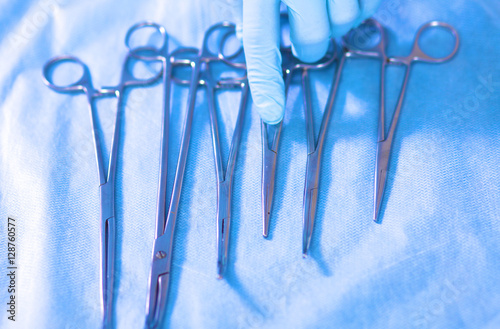 Detail shot of steralized surgery instruments with a hand grabbing tool