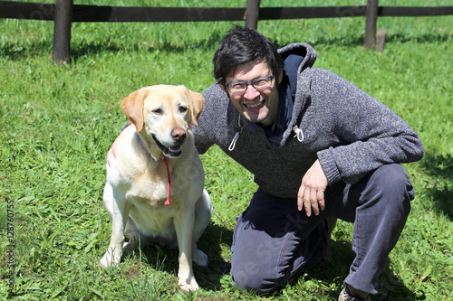 Foto young man with blacks hair smiling with labrador dog