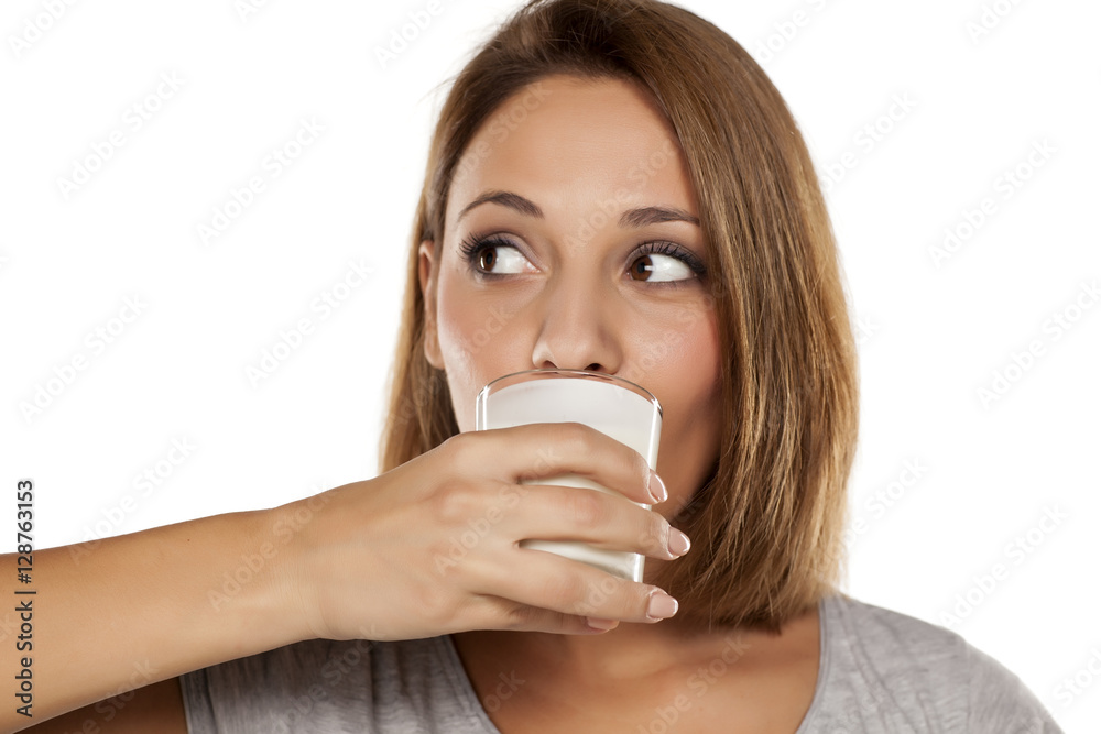 Young beautiful woman drinking milk from a glass Young beautiful woman drinking milk from a glass