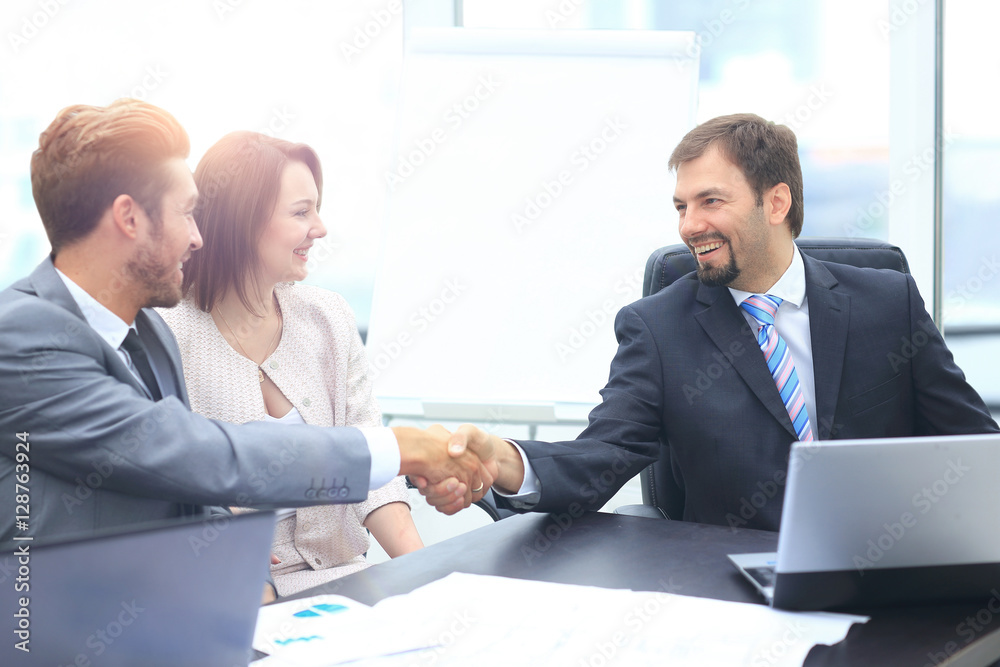 Business colleagues sitting at a table during a meeting with two Business colleagues sitting at a table during a meeting with two