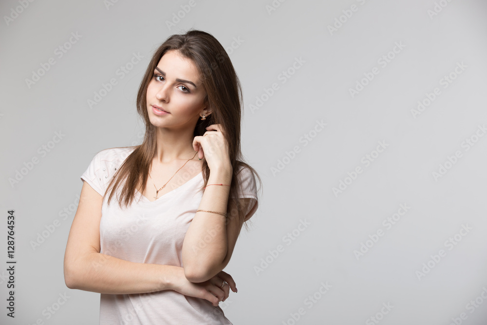 Portrait of beautiful brunette woman with natural make-up, on grey background Portrait of beautiful brunette woman with natural make-up, on grey background