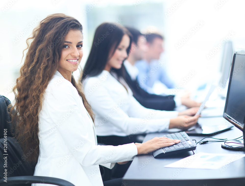 Happy young businesswoman looking behind and her colleagues work Happy young businesswoman looking behind and her colleagues work