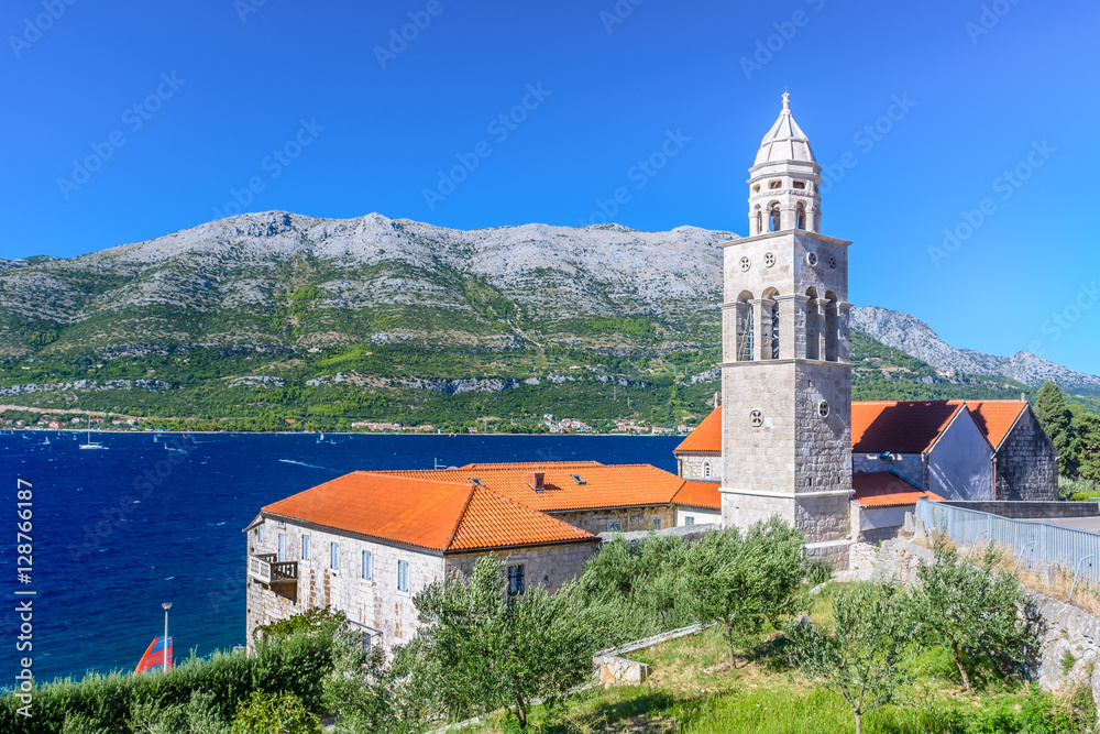 Fototapeta premium Dominican monastery Korcula island. / View at mediterranean landscape with Dominican Monastery in town Korcula with surfing place Viganj in background, Croatia summertime, Europe.