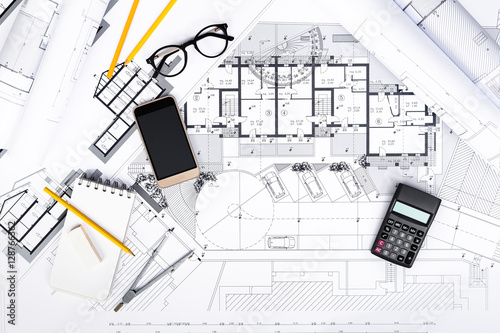 Construction plans with smartphone, calculator and drawing Tools