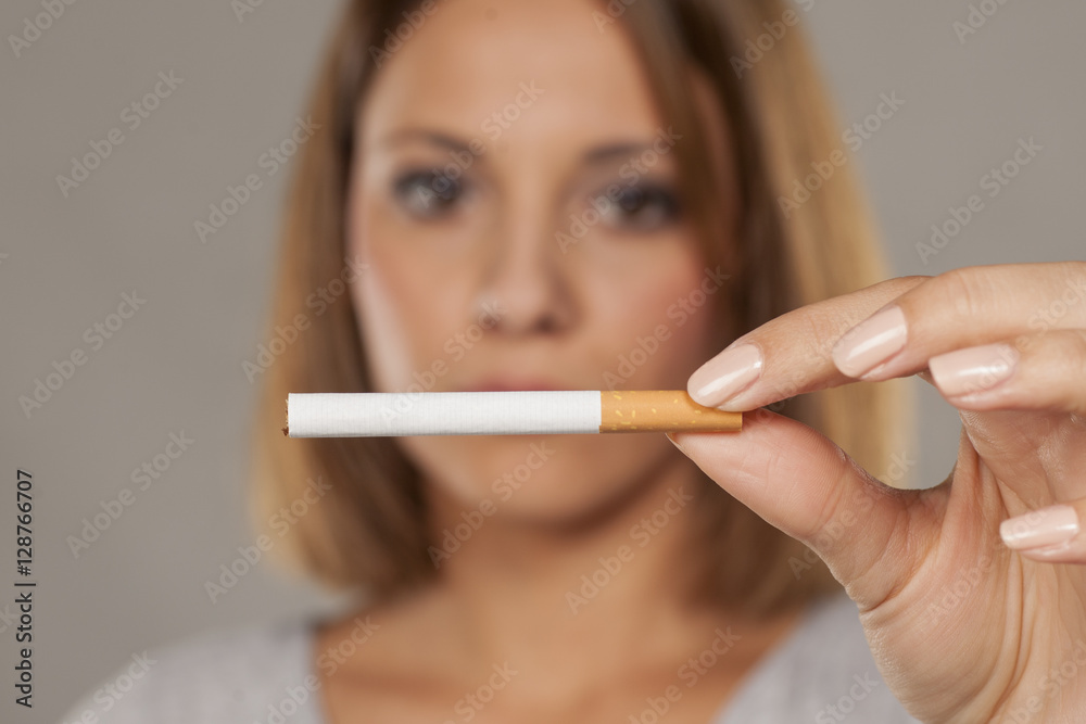 young beautiful woman holding a whole cigarette young beautiful woman holding a whole cigarette