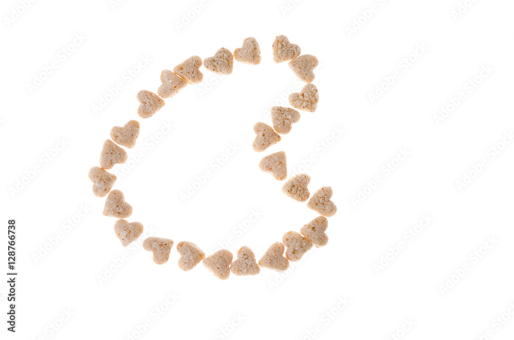 Oat muesli in the form of hearts on a white background Oat muesli in the form of hearts on a white background