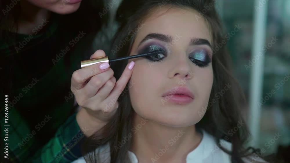 Make up artist applying on mascara on model's eyes slow motion Make up artist applying on mascara on model's eyes slow motion