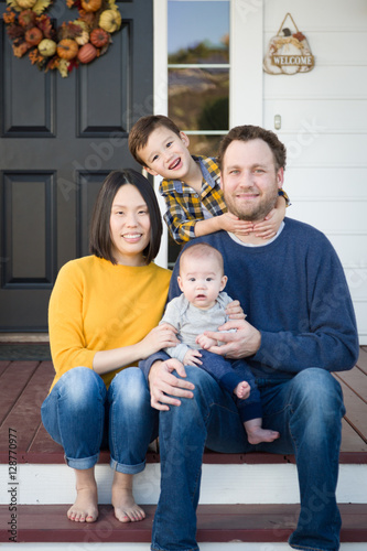 Young Mixed Race Chinese and Caucasian Family Portrait On Their Front Porch.