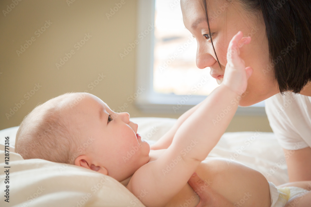 Young Mixed Race Chinese and Caucasian Baby Boy Laying In His Bed with His Mother. Young Mixed Race Chinese and Caucasian Baby Boy Laying In His Bed with His Mother.