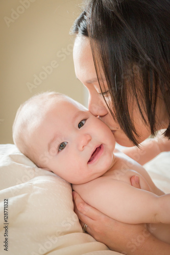 Young Mixed Race Chinese and Caucasian Baby Boy Laying In His Bed with His Mother.