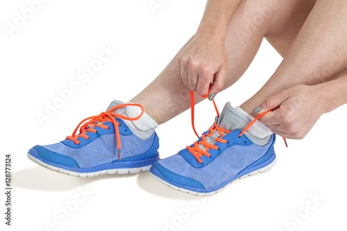 Athlete woman tying her running shoes
