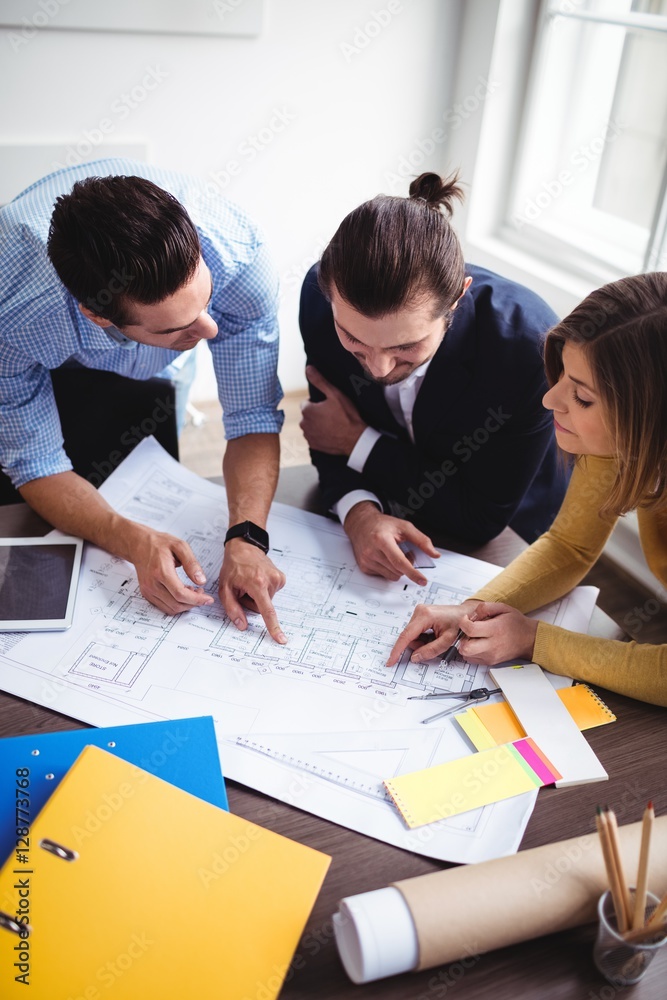 Business people discussing on blueprint Business people discussing on blueprint
