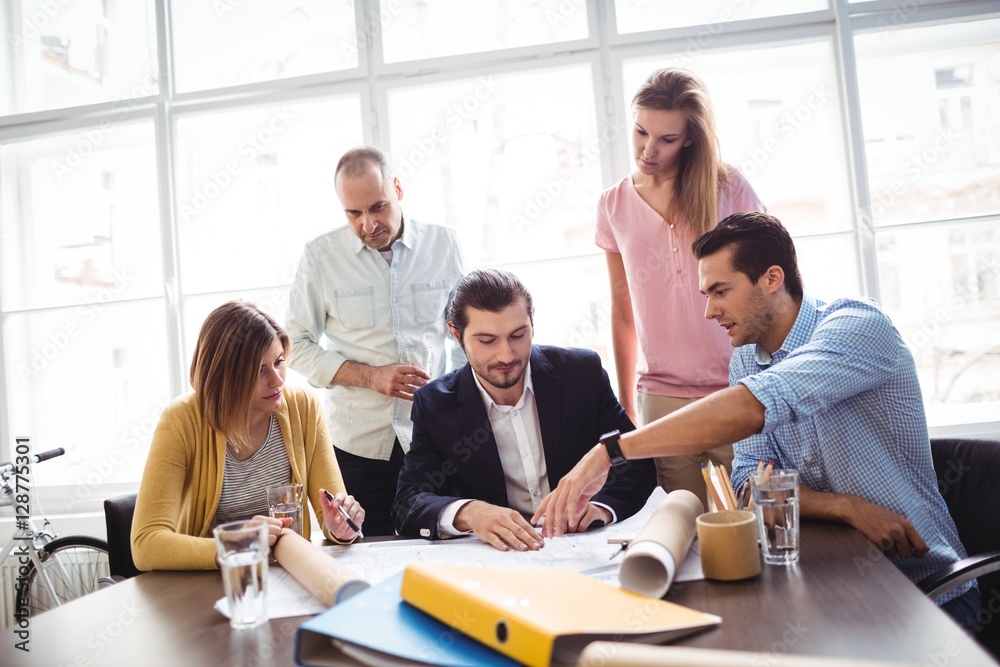 Businessman discussing with coworkers in meeting Businessman discussing with coworkers in meeting
