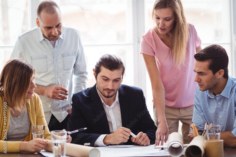 Fototapeta premium Businessman with coworkers looking at blueprint
