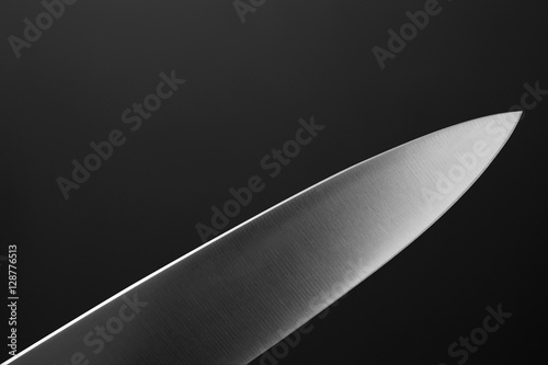 Leinwand Poster Big kitchen knife close up on dark background