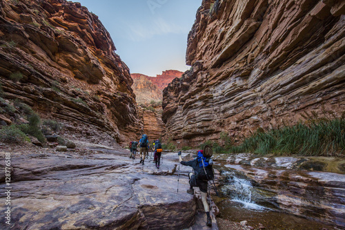 Grand Canyon hikers in rock tunnel with stream