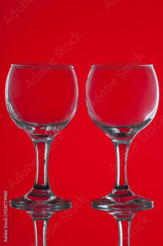 Two wine glasses on red background