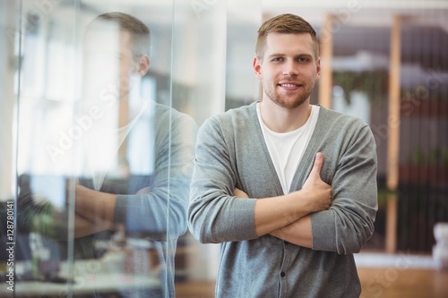 Portrait of happy businessman with arms crossed in office