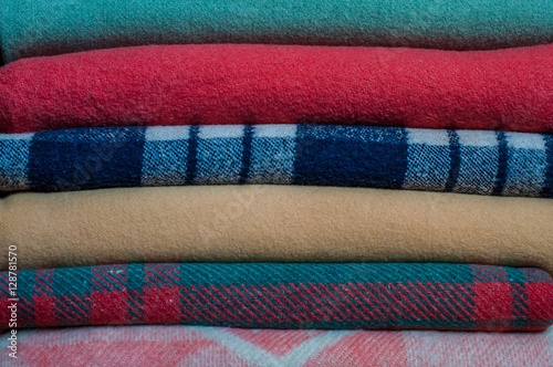 A stack of neatly folded colored blankets