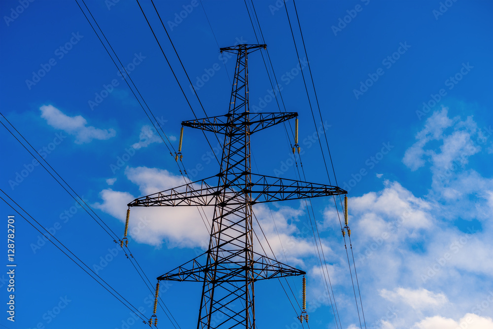 Pylon and transmission power line in summer at sunset.