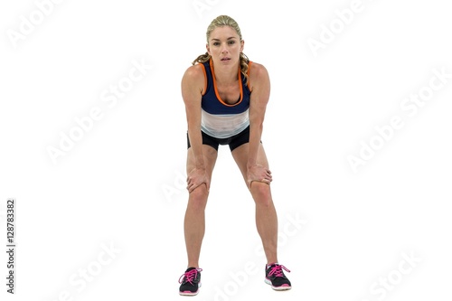 Tired athlete standing with hand on knee