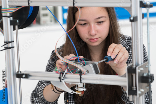 girl in robotics class research electronic device