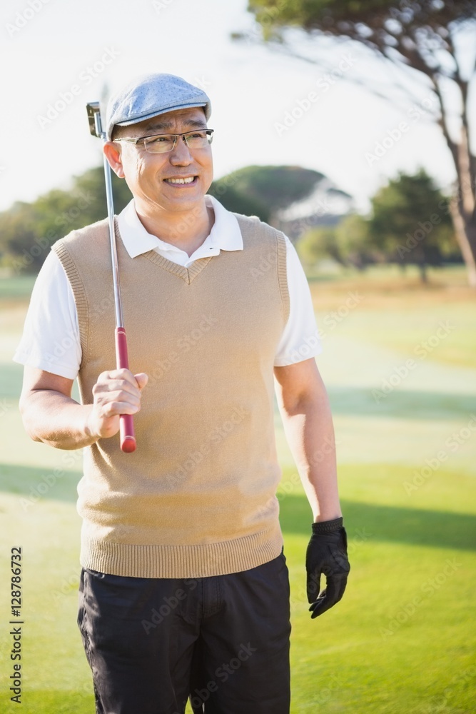 Portrait of sportsman holding his golf club and looking away Portrait of sportsman holding his golf club and looking away