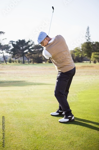 Side view of sportsman playing golf