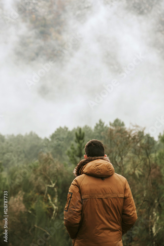 young man in the forest looking at the landscape © carballo