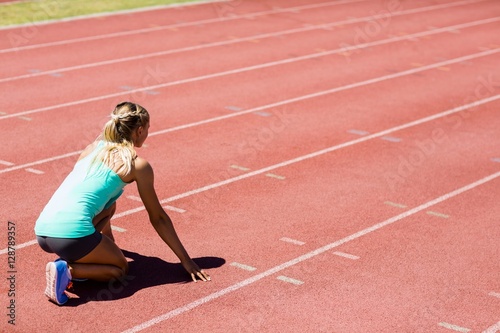 Female athlete ready to run on running track