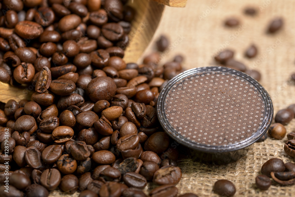 Fotografie coffee capsule with coffee beans on jute