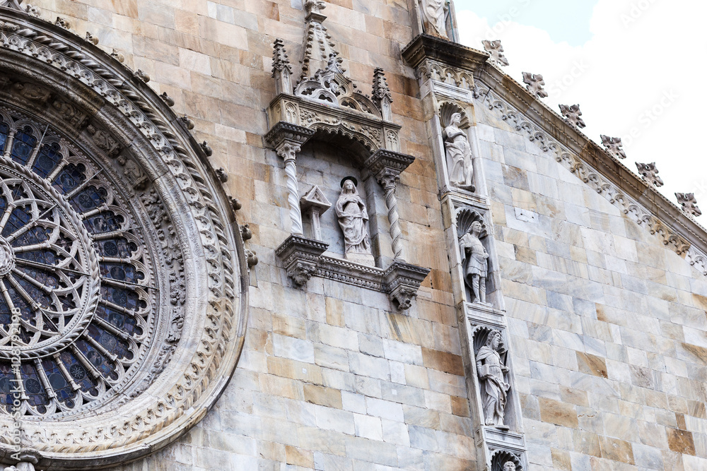 Facade of Cathedral in Como city, Lombardy, Italy. Exterior in from of the cathedral with Italian, Architectural, detail, sculpture, bas-relief Masonry carving, sculpture.