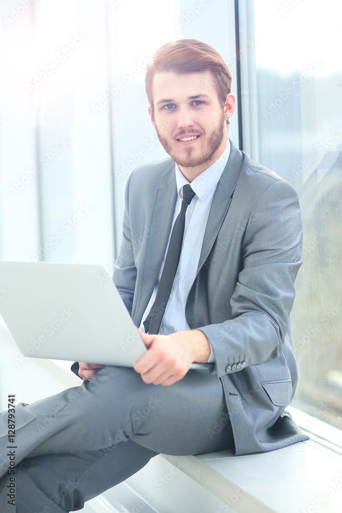Handsome businessman working with laptop in office Handsome businessman working with laptop in office