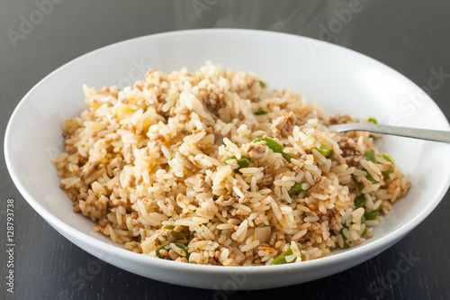Dirty riceA serving of dirty rice, a traditional cajun and creaole dish, in a white bowl with a fork