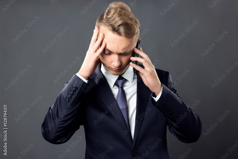 Handsome businessman on gray background stress and headache having migraine pain closeup black and white with red accent Handsome businessman on gray background stress and headache having migraine pain closeup black and white with red accent
