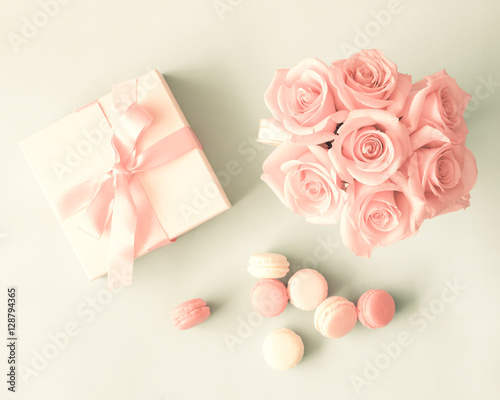 White box with red bow, French macarons and roses flat lay © Andreka Photography