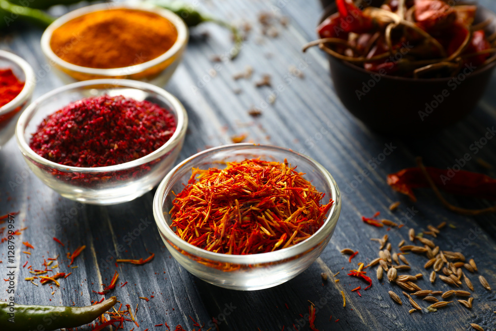 Aromatic spices in glass bowls on blue wooden background Aromatic spices in glass bowls on blue wooden background