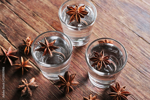 Vodka with anise on wooden background photo