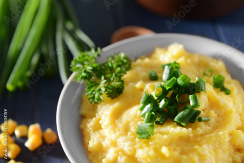 Tasty breakfast of cornmeal porridge with parsley and green onion, closeup