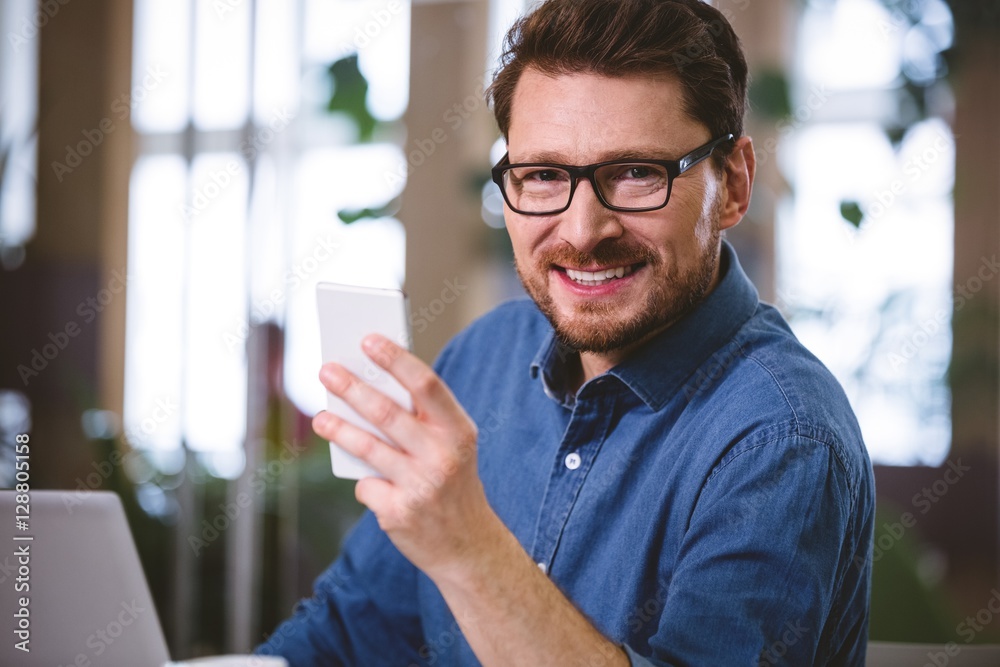 Portrait of confident businessman using mobile phone at office Portrait of confident businessman using mobile phone at office