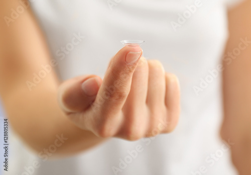 Woman holding contact lens  closeup