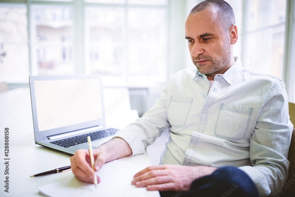 Thoughtful businessman writing document Thoughtful businessman writing document