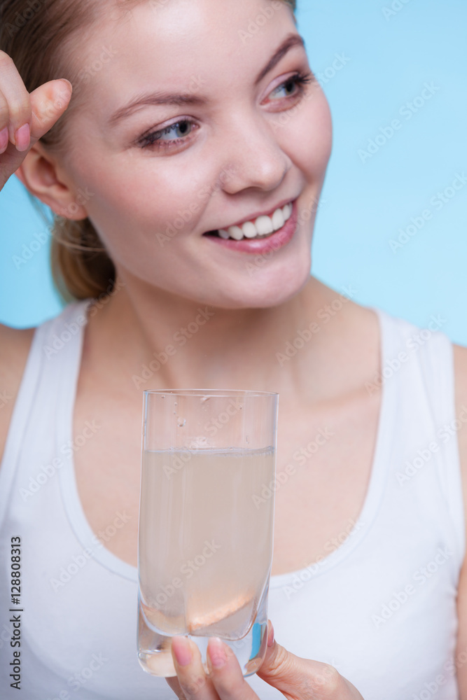 Woman holding glass with water and effervescent tablet Woman holding glass with water and effervescent tablet