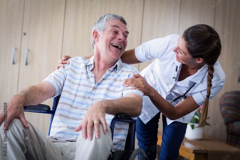 Obraz premium Happy senior man and doctor interacting in living room