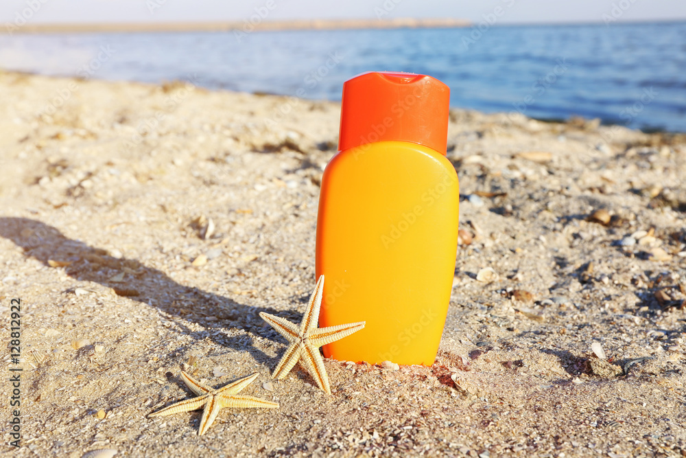 Sunscreen cream and starfish on sea coast Sunscreen cream and starfish on sea coast
