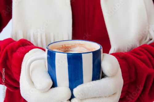 Woman in warm gloves holding cup of hot chocolate with marshmall photo