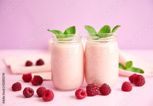 Berry milkshakes on color background